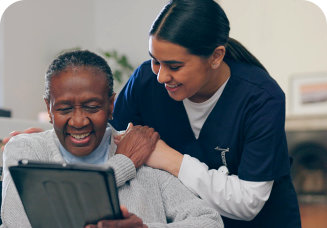 caregiver and senior man looking at the tablet